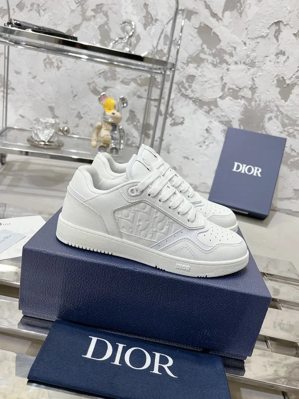 GALLERY X white leather Dior B27 low top sneakers with embossed Dior Oblique motif and perforated toe box.